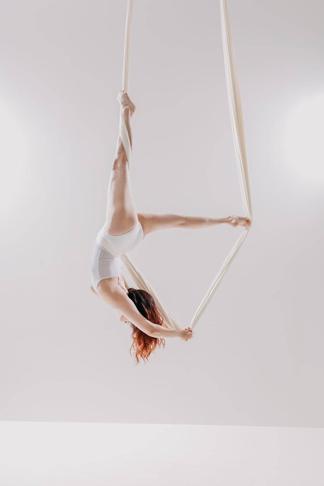 Dancer in a white aerial hammock on the light set