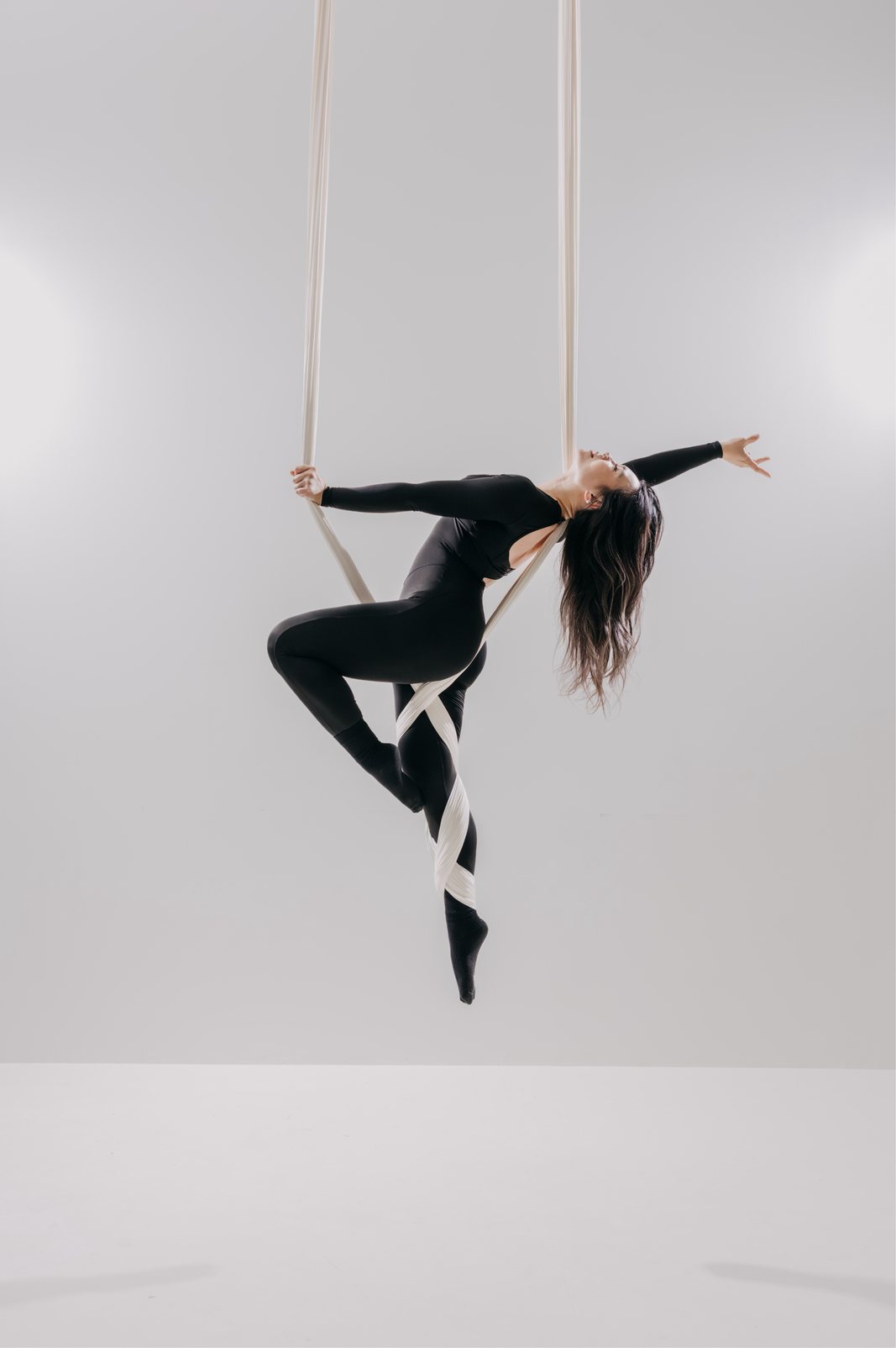 Dancer in a white aerial hammock on the light set