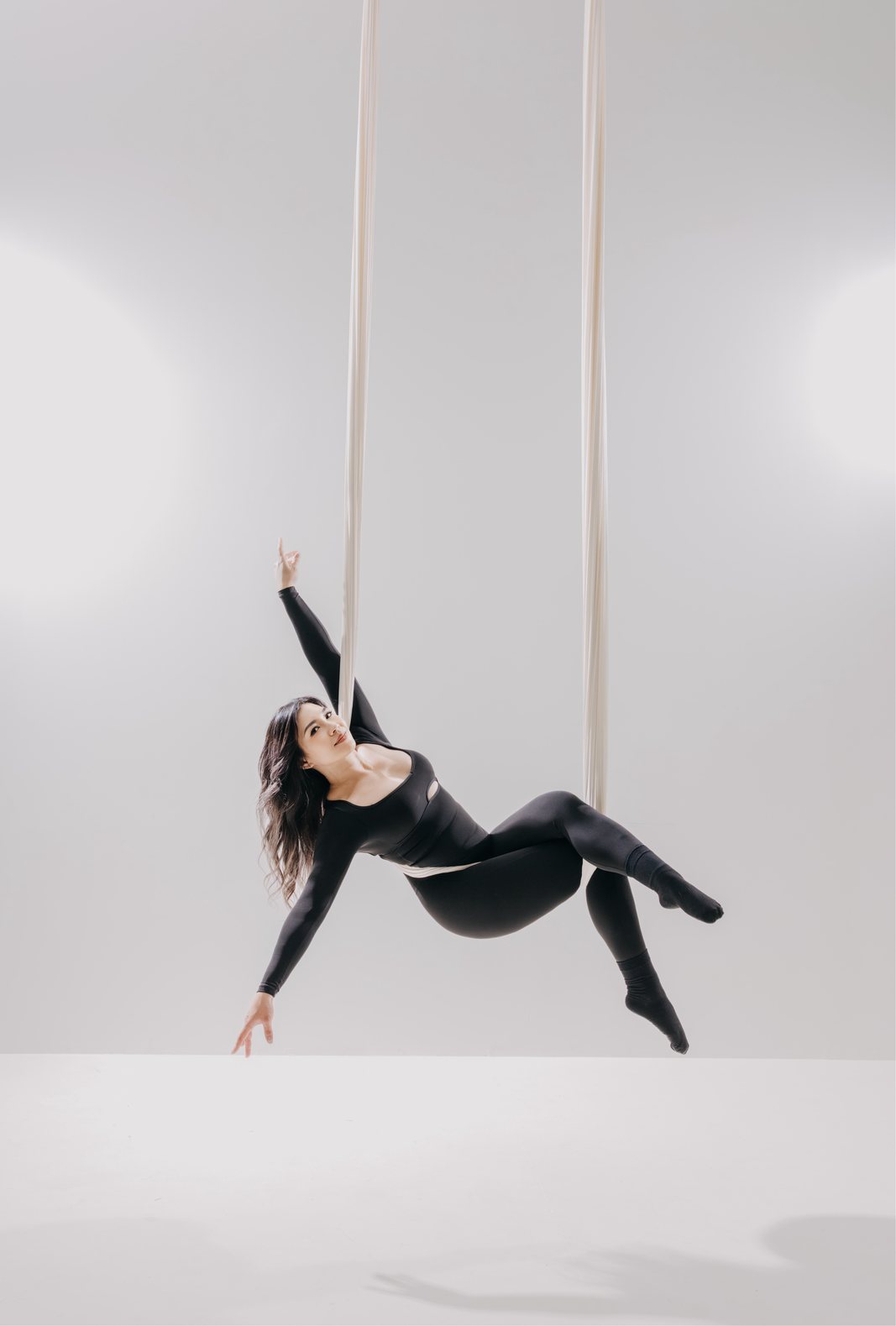 Dancer in a white aerial hammock on the light set