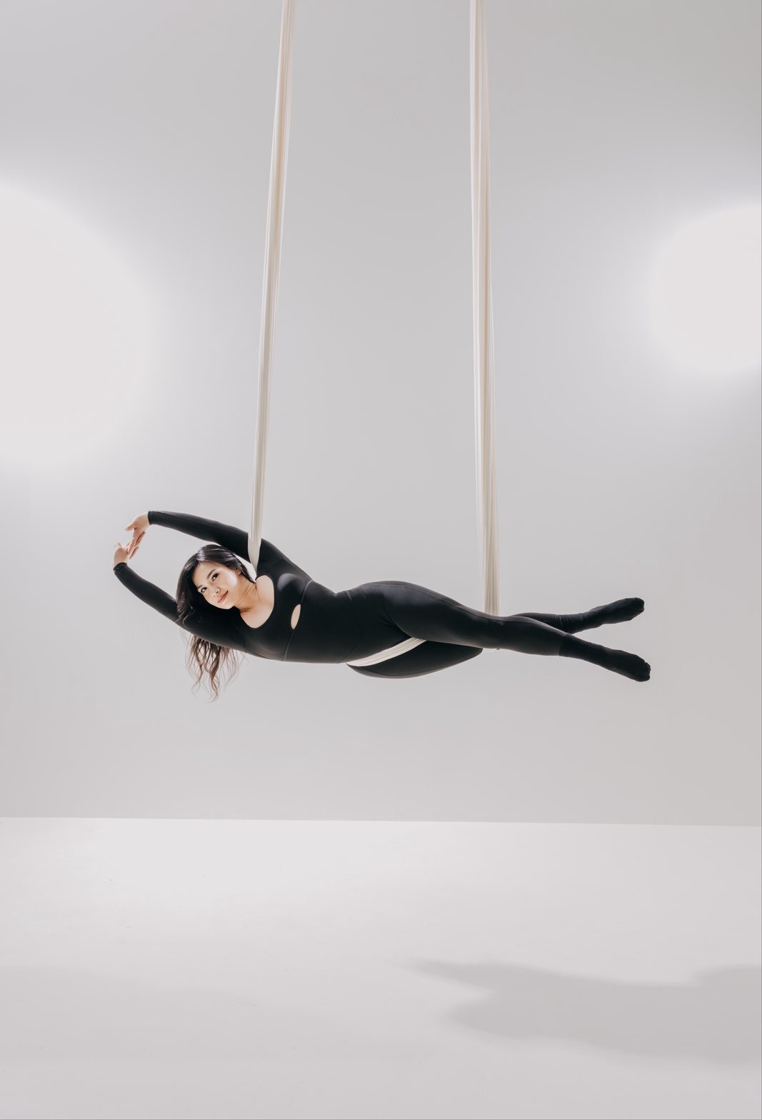 Dancer in a white aerial hammock on the light set